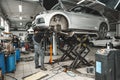 Auto mechanic repairs running gear of a car in car service