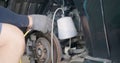 Auto mechanic replacing brake fluid on a vehicle