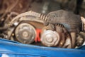 Auto mechanic shows a torn timing belt and peeled teeth on it Royalty Free Stock Photo