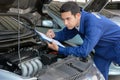 Auto mechanic (or technician) checking car engine
