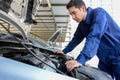 Auto mechanic (or technician) checking car engine