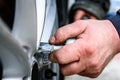 Auto mechanic with a torque wrench changing tires on wheels outside. Royalty Free Stock Photo