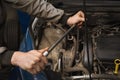 An auto mechanic unscrews the engine mount to replace the timing belt Royalty Free Stock Photo