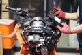 An auto mechanic uses a multimeter voltmeter to check the voltage level in a motorcycle , selective focus