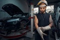 Auto-mechanic wearing welding gauntlets and protective helmet