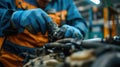 Auto mechanic working in auto repair service. Closeup of male hands in gloves repairing car engine. Royalty Free Stock Photo