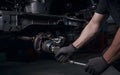 Auto mechanic working on car broken engine in mechanics service or garage.