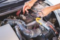 Auto mechanic working on car engine checking battery in mechanics garage, Repair and Maintenance service Royalty Free Stock Photo