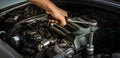 Auto mechanic working on car engine in mechanics garage. Repair service. Close-up shot Royalty Free Stock Photo