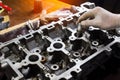 Auto mechanic working in garage. Repair service. opened automobile engine cylinder head