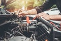 Auto mechanic working in garage Technician Hands of car mechanic working in auto repair Service and Maintenance car battery check Royalty Free Stock Photo