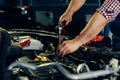 Auto mechanic working on car engine in mechanics garage Royalty Free Stock Photo