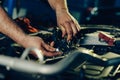 Auto mechanic working on car engine in mechanics garage Royalty Free Stock Photo