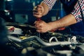 Auto mechanic working on car engine in mechanics garage Royalty Free Stock Photo