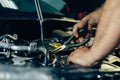 Auto mechanic working on car engine in mechanics garage Royalty Free Stock Photo