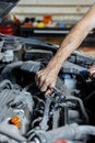 An auto mechanic works with a car engine in the mechanics' garage. Car repair close-up. Royalty Free Stock Photo