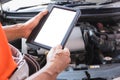 Auto mechanics are examining car while working in auto service, technician doing the checklist for repair car engine in the garage Royalty Free Stock Photo