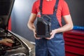 Auto mechanics hands holding canister in workshop