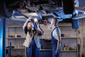 Auto Mechanics Inspecting Car on Lift Royalty Free Stock Photo