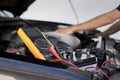 Auto mechanics use voltmeters to check battery voltage Royalty Free Stock Photo