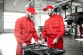 Auto mechanics with wrenches at the car service