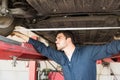 Auto Repair Shop Worker Measuring Tire Alignment With Tape