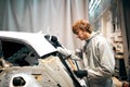 Auto repair worker flatten and align metal body car with hammer in garage Royalty Free Stock Photo