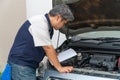 Auto repairman checks the engine and cooling system before traveling on a long holiday. Concept of Car care and maintenance from