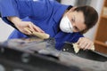 Auto repairman grinding autobody bonnet Royalty Free Stock Photo