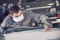 Auto repairman grinding autobody bonnet Royalty Free Stock Photo