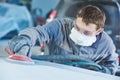 Auto repairman grinding autobody bonnet Royalty Free Stock Photo