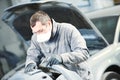 Auto repairman grinding autobody bonnet Royalty Free Stock Photo