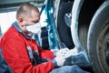 Auto repairman grinding automobile body Royalty Free Stock Photo