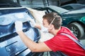 Auto repairman grinding automobile body Royalty Free Stock Photo