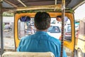 An auto rikshaw driver is stuck into city traffic