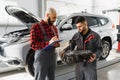 Auto service, repair, maintenance and people concept - mechanic men with wrench repairing car engine at workshop Royalty Free Stock Photo
