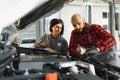 Auto service, repair, maintenance and people concept - mechanic men with wrench repairing car engine at workshop Royalty Free Stock Photo