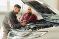 Auto service, repair, maintenance and people concept - mechanic men with wrench repairing car engine at workshop Royalty Free Stock Photo