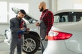 Auto service, repair, maintenance and people concept - mechanic men with wrench repairing car engine at workshop Royalty Free Stock Photo