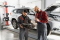 Auto service, repair, maintenance and people concept - mechanic men with wrench repairing car engine at workshop Royalty Free Stock Photo