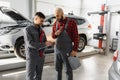 Auto service, repair, maintenance and people concept - mechanic men with wrench repairing car engine at workshop Royalty Free Stock Photo