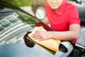 Auto service staff cleaning car rear windshield with microfiber