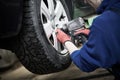 Auto service. Worker screwdriving an automobile wheel. Break maintenance or tyre replace Royalty Free Stock Photo
