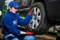 Auto service. Worker screwdriving an automobile wheel. Break maintenance or tyre replace Royalty Free Stock Photo