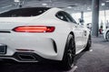 Auto show. Photo of the back of modern white colored beautiful car parked indoors