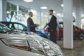 Auto showroom, dealer talking with buyer.