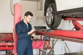 Auto Technician Making Checklist In Garage Royalty Free Stock Photo
