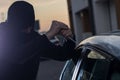 Auto thief in black balaclava trying to break into car Royalty Free Stock Photo