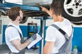 Auto workshop mechanics inspecting damage to car