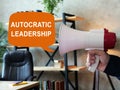 Autocratic leadership concept. Loudspeaker in hand and sign.